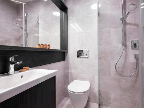 a bathroom with a shower and a toilet and a sink at Hotel Logos Kraków in Krakow