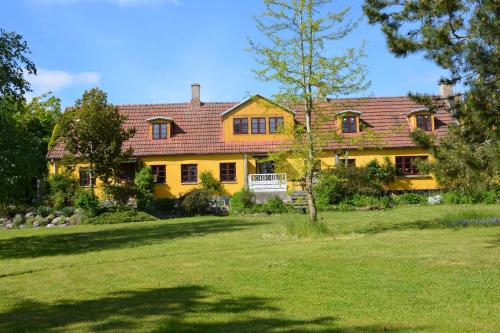 una gran casa amarilla con patio en Havehøjegaard, en Borre