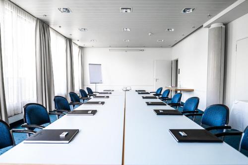 a long table in an office with blue chairs at Glärnischhof by TRINITY in Zürich