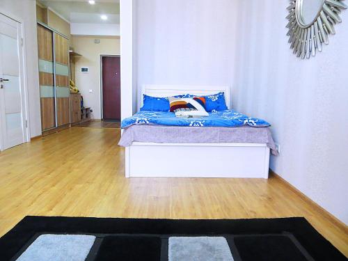 um quarto com uma cama com almofadas azuis em Panoramic studio apartments with mountain views em Bishkek