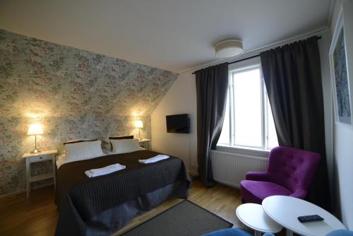 a hotel room with a bed and a purple chair at Örserumsbrunn Gestgifveri & Konferens in Gränna