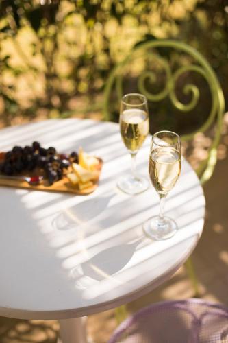 two glasses of wine sitting on a white table at Mandraki Village Boutique Hotel in Koukounaries