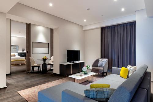 a living room with a couch and a tv at Taj Jumeirah Lakes Towers in Dubai