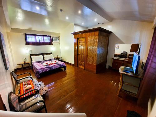 a bedroom with a bed and a couch and a television at Cocoloco Beach Resort in Boracay