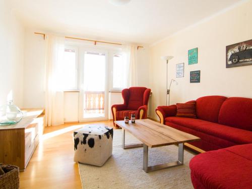 a living room with a red couch and a coffee table at Apartment in the Black Forest with balcony in Urberg