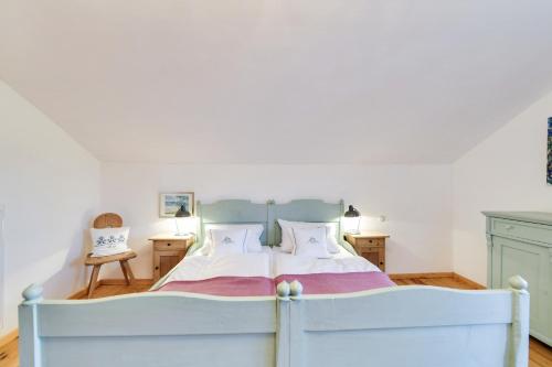 ein Schlafzimmer mit einem weißen Bett mit zwei Kissen in der Unterkunft Ferienwohnung Bergfex Alte Gendarmerie Übersee in Übersee