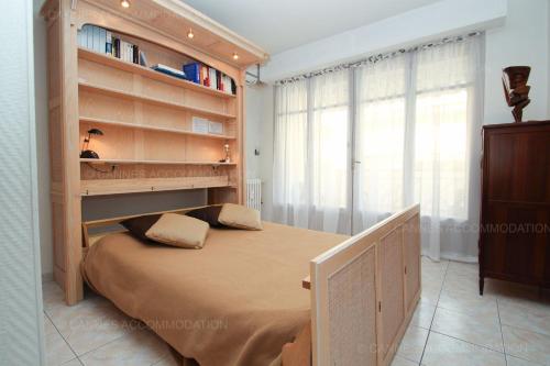 une chambre avec un lit et une étagère dans l'établissement Jonquille, à Cannes