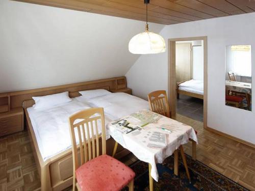 a bedroom with a bed and a table and chairs at Pension Braun in Winterberg