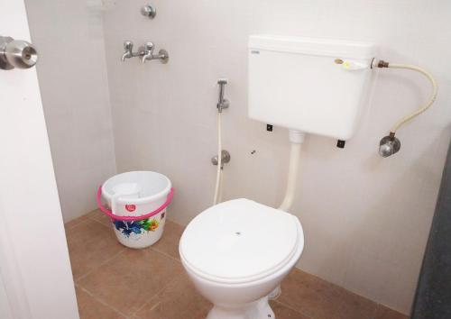 baño con aseo blanco y cubo de basura en Honey Bee Serviced Apartments Trivandrum, en Trivandrum