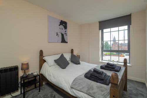 a bedroom with a bed with towels on it at Stylish & Cosy Apartment in Nottingham