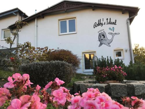a house with a sign on the side of it with pink flowers at Haus Krabbe mit Strandkorb inkl in Göhren