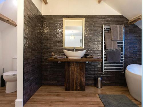 a bathroom with a sink and a mirror at Chapel House Cottage in Builth Wells