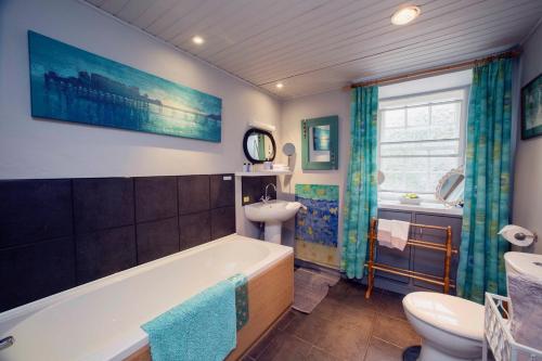 ein Badezimmer mit einer Badewanne, einem Waschbecken und einem WC in der Unterkunft Langside Bed and Breakfast in Fenwick