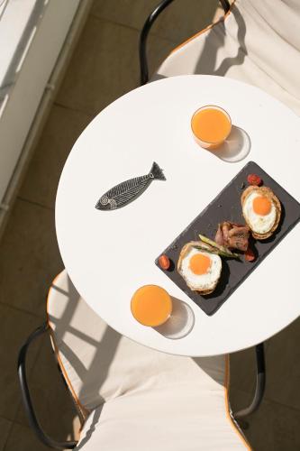 a white table with a plate of food on it at Mandraki Village Boutique Hotel in Koukounaries