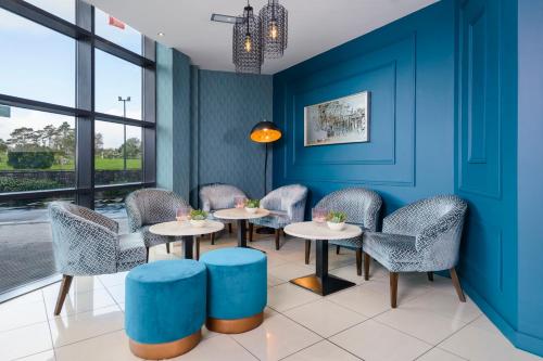 a restaurant with blue walls and tables and chairs at The Ellison in Castlebar