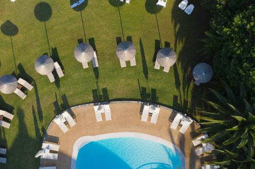an overhead view of a pool with chairs and umbrellas at Mandraki Village Boutique Hotel in Koukounaries