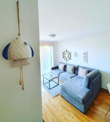 a living room with a blue couch and a table at Charming apartment near beach in Sveti Stefan