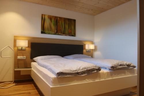 a bedroom with a bed with a painting on the wall at Schwarzwaldhuus Feldberg in Feldberg