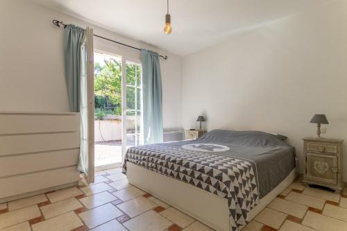 Un dormitorio con una cama y una puerta corrediza de vidrio. en Villa les Pins, en Callas