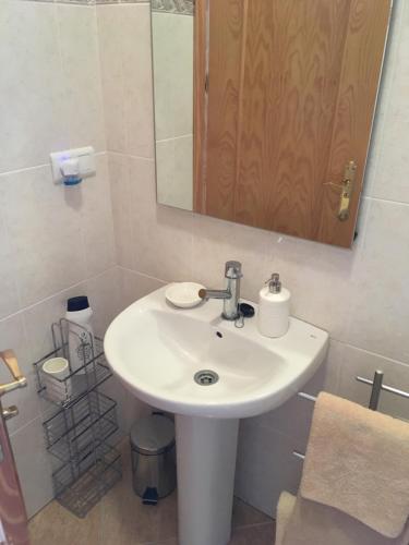 een badkamer met een witte wastafel en een spiegel bij Torrox Pueblo Hidden Gem, 2 Bed Apartment in Torrox