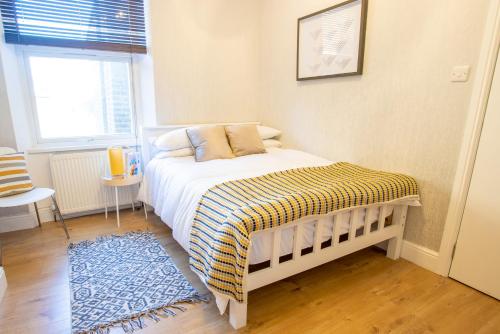 a small bedroom with a bed and a window at Modern 1 Bed Studio Flat in West Kilburn by Queen's Park for 2 people in London