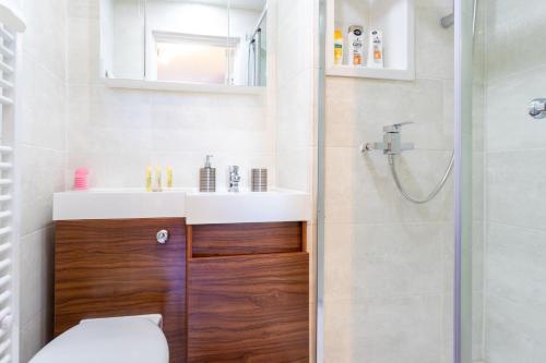 a bathroom with a toilet and a sink and a shower at Modern 1 Bed Studio Flat in West Kilburn by Queen's Park for 2 people in London