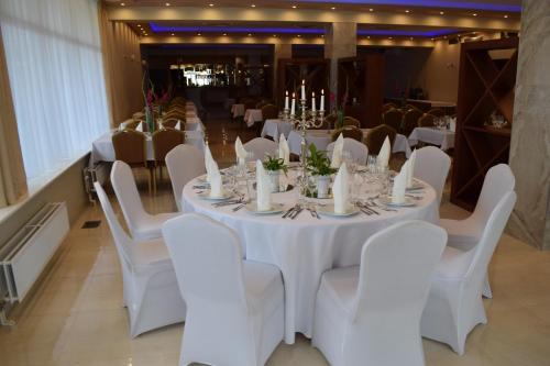 a room with white tables and chairs and candles at Hotel Biały in Wałbrzych
