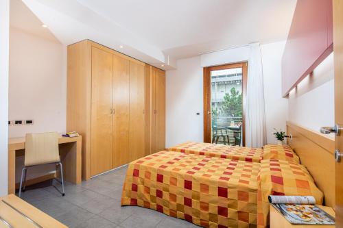 Schlafzimmer mit einem Bett, einem Schreibtisch und einem Tisch in der Unterkunft Residence AIRONE in Lignano Sabbiadoro