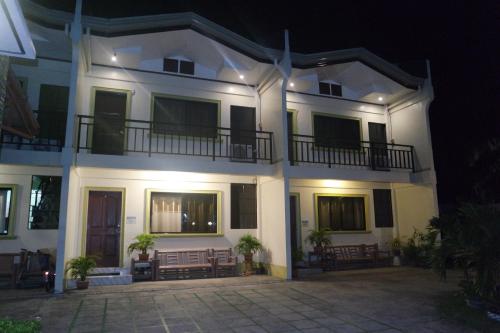 a large white building with a courtyard at night at Yoo C Apartment in Dumaguete