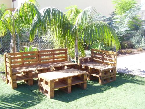two wooden benches sitting next to each other on the grass at Casa Doña Justa in Tegueste