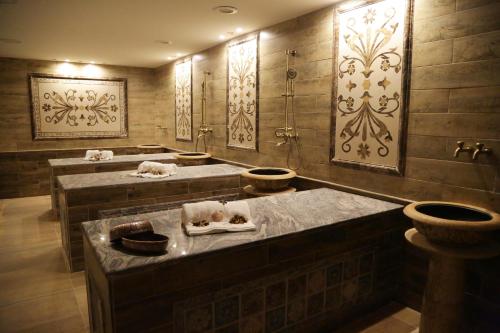 a bathroom with three sinks and two toilets at Opal Hotel Amman in Amman