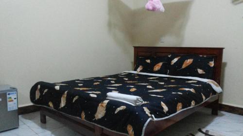 a bedroom with a bed with a black and brown comforter at Hotel Premier in Yumbe
