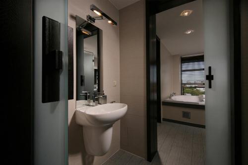 a bathroom with a sink and a toilet and a mirror at Reghina Blue Hotel in Timişoara