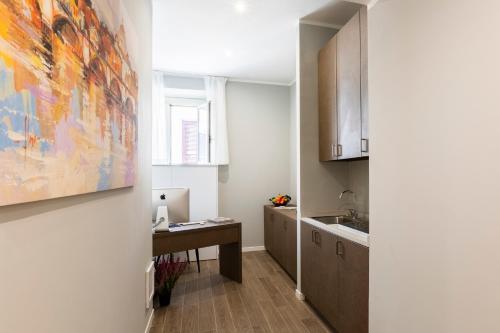 a kitchen with a table and a sink and a painting at Giubbonari Suites in Rome