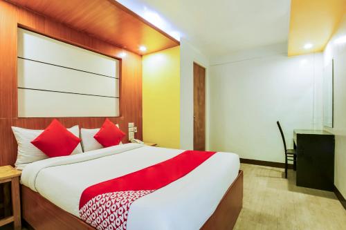 a bedroom with a large bed with red pillows at OYO 473 Ranchotel Drive-in in Biñan