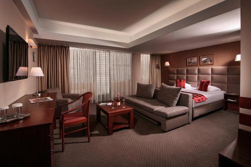 a hotel room with a bed and a living room at Reghina Blue Hotel in Timişoara