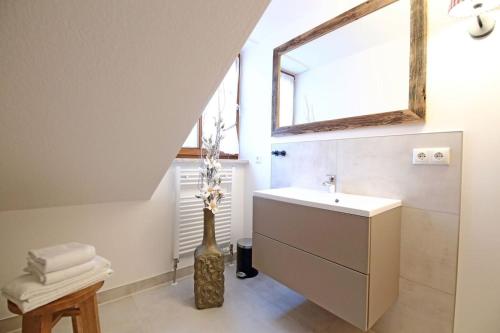 a bathroom with a sink and a vase with flowers at Aparthotel Deutscher Kaiser Ferienwohnungen in Kurort Oberwiesenthal