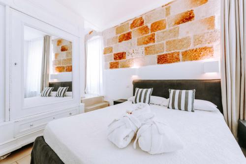 a bedroom with a white bed with towels on it at Dimora Anderì in Polignano a Mare