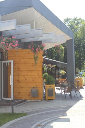 a patio with chairs and tables and a building at Motel Kurortnyy & SPA in Shklo