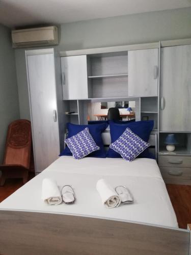 - une chambre avec un lit doté d'oreillers bleus et de chaussons dans l'établissement Maison D architecte chez Huguette, à Villalier