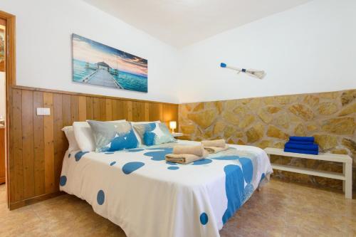 a bedroom with a large bed with blue and white sheets at El Charco in Órzola