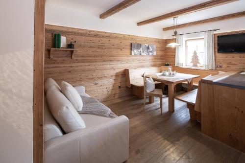 a living room with a white couch and a table at Loefflerhof in Monguelfo