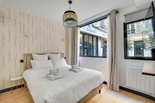 Un dormitorio con una gran cama blanca y una ventana en Pick A Flat's Apartment in Opera - Rue Grange Batelière, en París