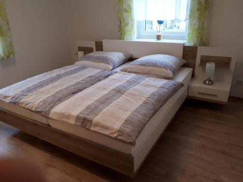 a bedroom with a large bed with two pillows at Ferienwohnung Karlguth in Neustadt in Sachsen