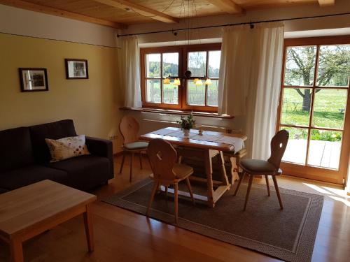 a living room with a table and chairs and a couch at Holzhauser Hof in Waldkraiburg