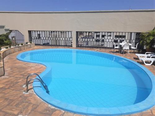 een groot zwembad met blauw water bij La Residence Flat Hotel in Goiânia