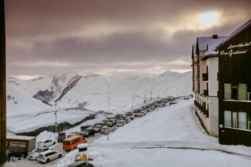 a row of cars parked on a street covered in snow at Tedy's Apartments in New Gudauri in Gudauri