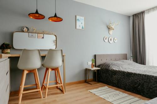 two chairs in a bedroom with a bed at Tedy's Apartments in New Gudauri in Gudauri
