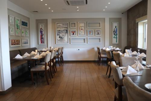 a dining room with tables and chairs and pictures on the wall at Mamba Point Hotel in Monrovia
