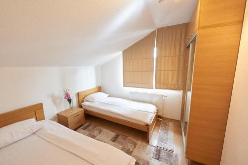 a small bedroom with two beds and a window at Grand Apartments-For Groups in Sarajevo